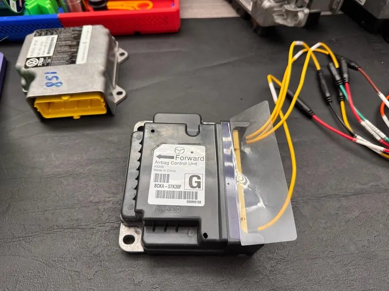 Close-up of Mazda BCKA-57K30F airbag module connected to bench wiring