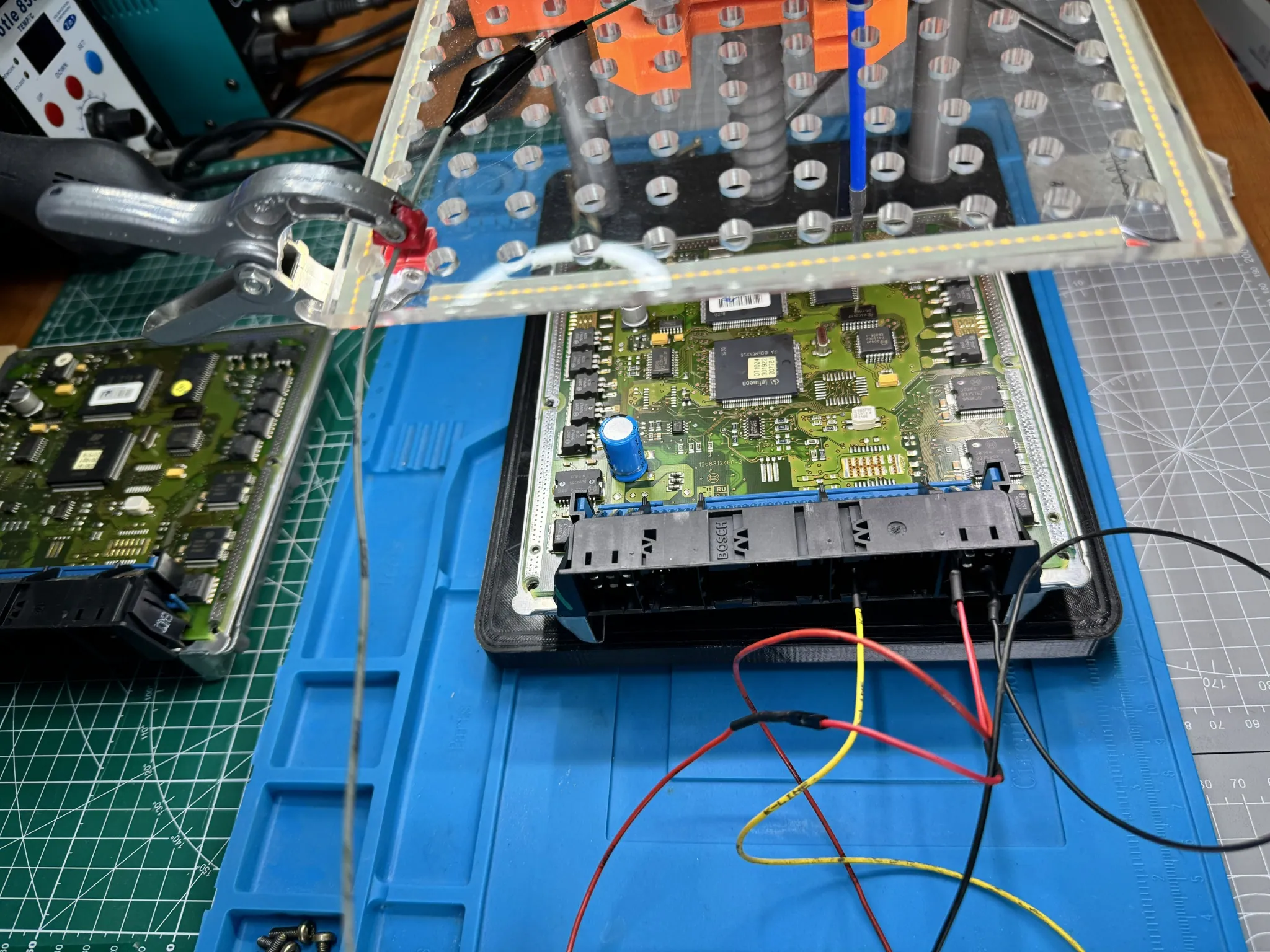 Mercedes Bosch ME2.8 ECU opened on bench with programming probes and a protected circuit board