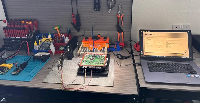 K-TAG programming interface beside opened PSA ECU and bench programming equipment.