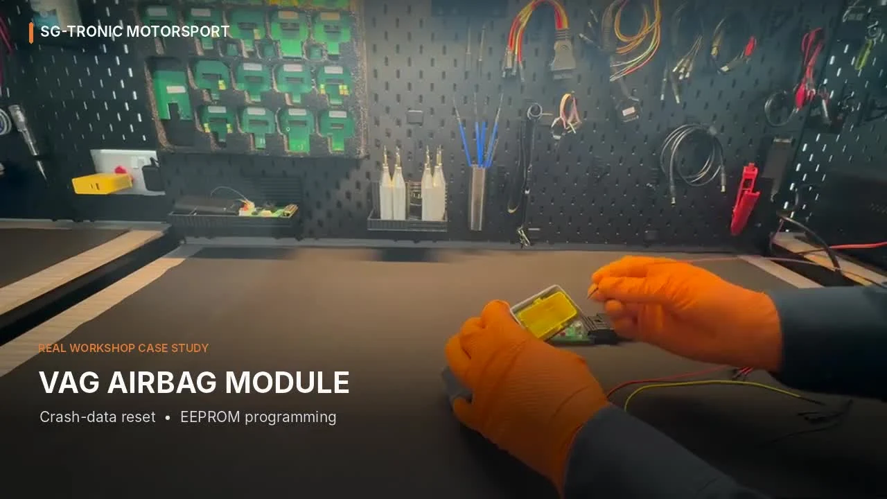 Technician wearing orange gloves connects VAG airbag ECU to workshop programming equipment