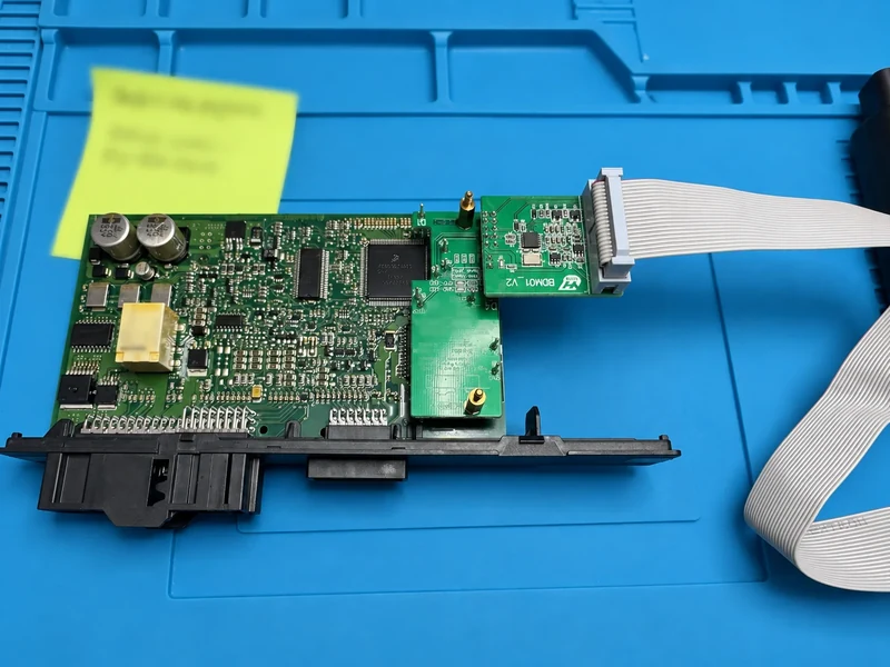 BMW CAS3+ circuit board with yellow sticky note blurred during diagnostics and module programming