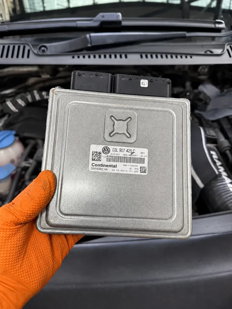 VW Caddy ECU module held in front of the engine bay